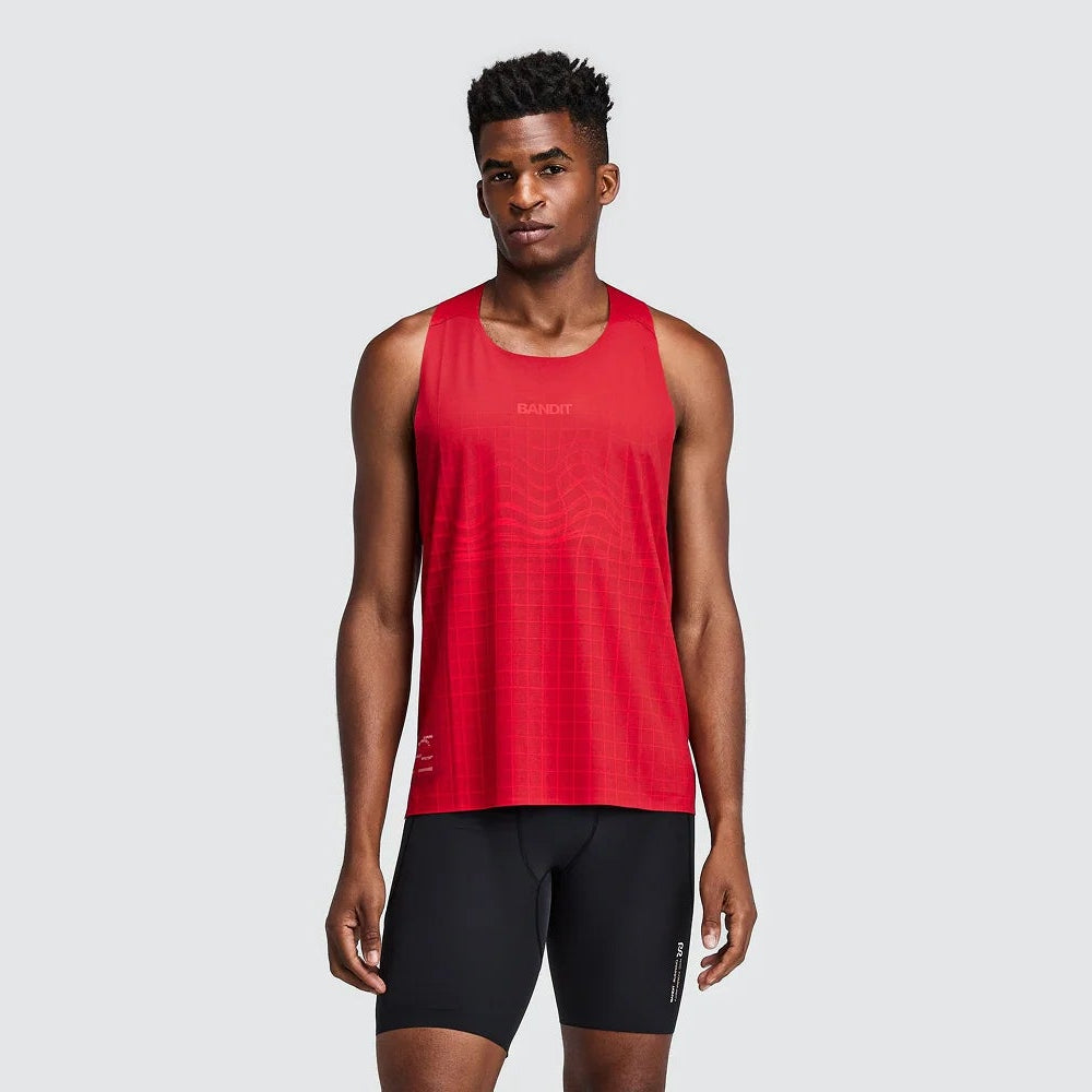 A male model wearing a red sleeveless athletic tank top and black running shorts, standing against a solid light gray background.