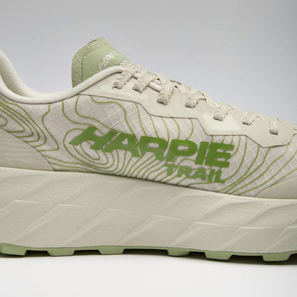 A close-up side view of a Harpie Trail sneaker in off-white and light green, featuring a thick textured sole and &