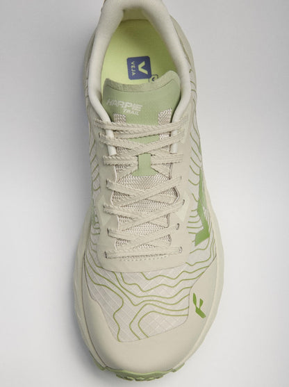 A single trail running shoe shown from a top-down angle on a light gray background. The shoe is primarily off-white with light green accents, including the tongue, inner lining, and topographic contour line patterns on the side and toe.