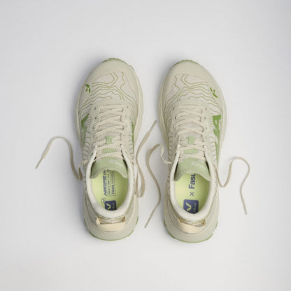 A pair of light beige and green running shoes viewed from a top-down angle on a light gray background.